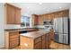 Bright kitchen featuring an island, stainless appliances, and custom wood cabinets at 15028 Clayton St, Thornton, CO 80602