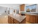 Open kitchen with an island, stainless appliances, lots of storage, and exterior views at 15028 Clayton St, Thornton, CO 80602