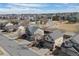 An aerial view shows a suburban neighborhood with well-maintained homes, green spaces, and a community pool under a blue sky at 15028 Clayton St, Thornton, CO 80602