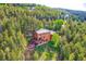 Expansive aerial view of a house nestled among lush forest, with a peek of neighboring homes at 11876 Coal Creek Heights Dr, Golden, CO 80403