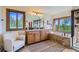 A luxurious bathroom with a soaking tub, double sink vanity, and natural light at 11876 Coal Creek Heights Dr, Golden, CO 80403