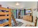 A room with a bunk bed, a dresser with a mirror, and blue curtains at 11876 Coal Creek Heights Dr, Golden, CO 80403