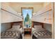 Charming bunk room featuring two sets of wooden bunk beds and a window with serene views at 11876 Coal Creek Heights Dr, Golden, CO 80403