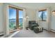 Bedroom with large windows offering a great view and furnished with an armchair and ottoman at 11876 Coal Creek Heights Dr, Golden, CO 80403