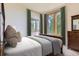 This is a cozy bedroom featuring two large windows with curtains and a wooden dresser at 11876 Coal Creek Heights Dr, Golden, CO 80403