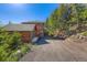 Exterior view of a home with a detached garage and gravel driveway at 11876 Coal Creek Heights Dr, Golden, CO 80403