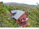 Scenic view of a charming home featuring a well-maintained deck among lush trees and foliage at 11876 Coal Creek Heights Dr, Golden, CO 80403