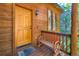 Inviting front porch with a wooden bench, stylish door, and charming exterior details at 11876 Coal Creek Heights Dr, Golden, CO 80403