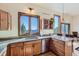 Bright kitchen featuring wood cabinets, granite countertops, and a stainless steel dishwasher with amazing views at 11876 Coal Creek Heights Dr, Golden, CO 80403