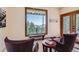 Inviting sitting area with large window showcasing breathtaking mountain views and a walk out patio at 11876 Coal Creek Heights Dr, Golden, CO 80403