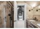 View of the bathroom featuring a shower, vanity, and a sunlit hallway at 120 Cherokee St, Denver, CO 80223
