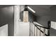 View of the carpeted upper hallway with gray walls, a skylight, and a decorative wrought iron railing at 120 Cherokee St, Denver, CO 80223