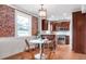 Bright eat-in kitchen with stainless steel appliances, a kitchen island, and brick accent wall at 120 Cherokee St, Denver, CO 80223