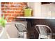 Stylish kitchen bar area with marble countertops, stainless steel chairs, and brick accents at 120 Cherokee St, Denver, CO 80223