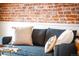 Cozy living room with a blue sofa, plush pillows, brick wall, and wainscoting at 120 Cherokee St, Denver, CO 80223