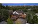 Aerial view of the brick home with outdoor seating and a tree-lined neighborhood in front of a city skyline at 375 S University Blvd, Denver, CO 80209