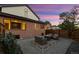 Well-lit backyard patio with gravel and brick accents, offering ample seating near the home's brick exterior at 375 S University Blvd, Denver, CO 80209