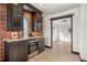 Elegant bar area featuring custom cabinets, a wine fridge, and brick accents at 375 S University Blvd, Denver, CO 80209