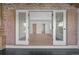 Hallway with brick walls leading to a bedroom area featuring natural wood floors and white trim at 375 S University Blvd, Denver, CO 80209