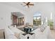 Bright living room featuring modern furniture, a vaulted ceiling, a ceiling fan, and a large arched window at 375 S University Blvd, Denver, CO 80209