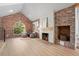 Bright living room boasts a fireplace, exposed brick and seating area with hardwood floors at 375 S University Blvd, Denver, CO 80209