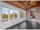 Bright sunroom featuring black tile floors, wood ceilings, brick accent wall, and natural light at 375 S University Blvd, Denver, CO 80209