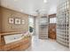 Bathroom featuring a luxurious soaking tub with a stone surround and a glass block shower at 1185 W 140Th Dr, Westminster, CO 80023