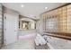 Spa-like bathroom with glass block wall, soaking tub, dual sinks, and elegant tile flooring at 1185 W 140Th Dr, Westminster, CO 80023