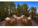 Outdoor deck with a fire pit and comfortable seating surrounded by mature trees at 6111 Huron Pl, Castle Rock, CO 80108