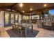 Elegant outdoor dining area with seating for six, wood ceiling, and backyard views at 6111 Huron Pl, Castle Rock, CO 80108