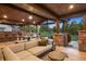 Covered outdoor living space featuring a stone bar, dining, and lounge area with a wood ceiling at 6111 Huron Pl, Castle Rock, CO 80108