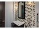 Stylish powder room featuring unique geometric tile, modern vanity, and decorative lighting for a sophisticated touch at 6111 Huron Pl, Castle Rock, CO 80108