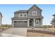 Charming two-story home with a gray exterior, covered front porch, and manicured front yard at 11039 Snowdon St, Parker, CO 80134