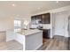 Contemporary kitchen with a white kitchen island, dark cabinets, and stainless steel appliances at 11039 Snowdon St, Parker, CO 80134