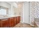 Bathroom with double vanity, neutral countertops, decorative wallpaper, and tiled floor at 16043 Azalea Ave, Parker, CO 80134