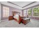 Spacious bedroom featuring a wooden bed frame, tray ceiling, and natural light at 16043 Azalea Ave, Parker, CO 80134