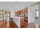 Modern kitchen boasts stainless steel appliances, a large island with seating, and hardwood floors at 16043 Azalea Ave, Parker, CO 80134