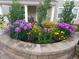 Stone-lined landscaping bed filled with blooming annuals adds curb appeal at 16043 Azalea Ave, Parker, CO 80134