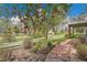 Lush backyard garden with flowering trees, stone pathway, and views of the surrounding walking path at 20591 E Weaver Ave, Aurora, CO 80016