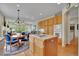Open kitchen with an island cooktop, oak cabinets, and an adjacent breakfast nook and living area at 20591 E Weaver Ave, Aurora, CO 80016