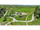 Aerial view of park featuring a playground, walking path, green space, and a canopy of trees and homes in the background at 20591 E Weaver Ave, Aurora, CO 80016