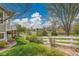 Green backyard with mature trees, manicured lawn, and a charming white fence at 20591 E Weaver Ave, Aurora, CO 80016
