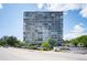 Exterior view of the high-rise condo building with parking and landscaping at 3100 E Cherry Creek South Dr # 1403, Denver, CO 80209