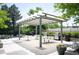 Outdoor kitchen and dining area with multiple grills and seating under a pergola at 3100 E Cherry Creek South Dr # 1403, Denver, CO 80209