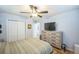 Bedroom with ceiling fan, hardwood floors, closet, and view to ensuite bathroom at 7820 Tejon St, Denver, CO 80221
