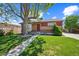 Charming brick home with a well-manicured lawn and mature shade tree at 7820 Tejon St, Denver, CO 80221