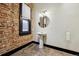 Bathroom with brick wall, pedestal sink, and updated fixture at 308 Inca St, Denver, CO 80223
