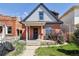 Charming brick home featuring a welcoming front porch and vibrant landscaping at 308 Inca St, Denver, CO 80223
