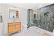 Modern bathroom featuring sleek glass-enclosed shower, wood vanity, and chic black and white tiled flooring at 2000 Arapahoe St # 503, Denver, CO 80205