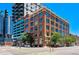 Brick building featuring large windows and streetscape with pedestrian crossing on a clear blue day at 2000 Arapahoe St # 503, Denver, CO 80205
